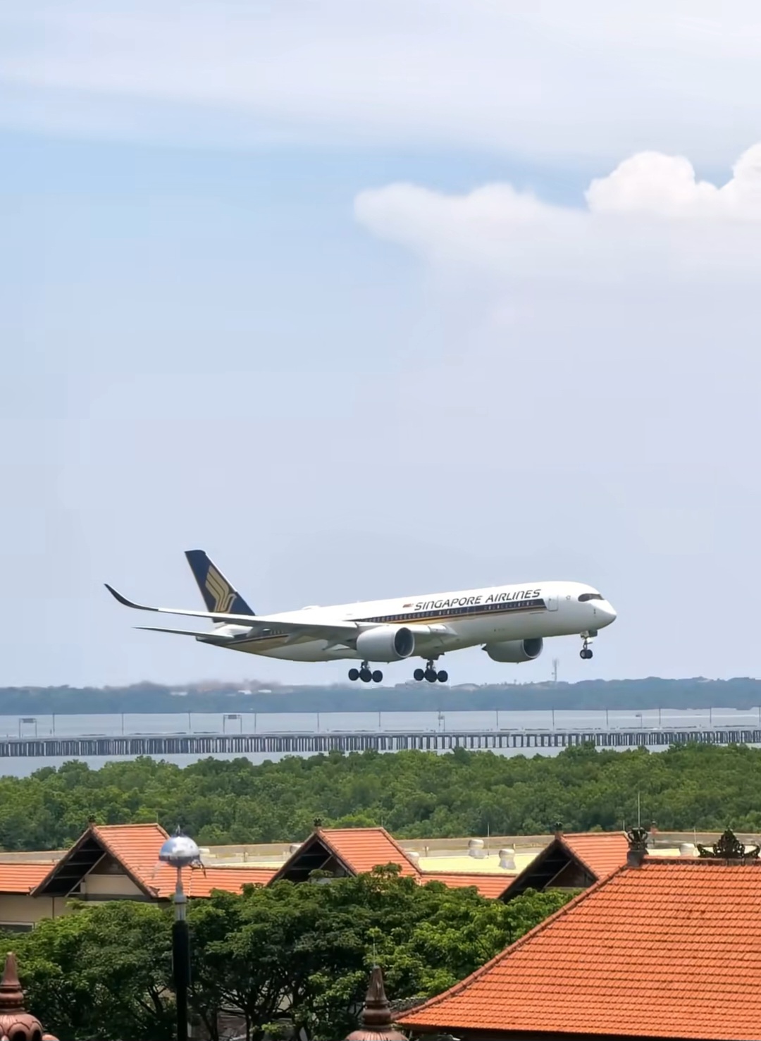Singapore Airlines A350 on approach over Balinese rooftops at Ngurah Rai International Airport